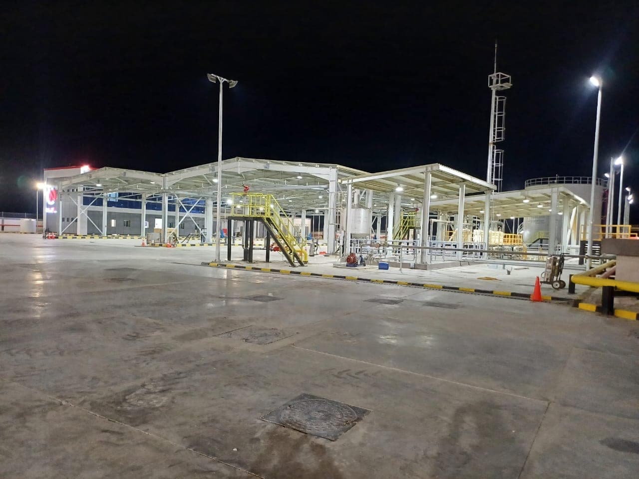 The illuminated fuelling canopy and steel structure at the Al-Alamein fuel depot at night