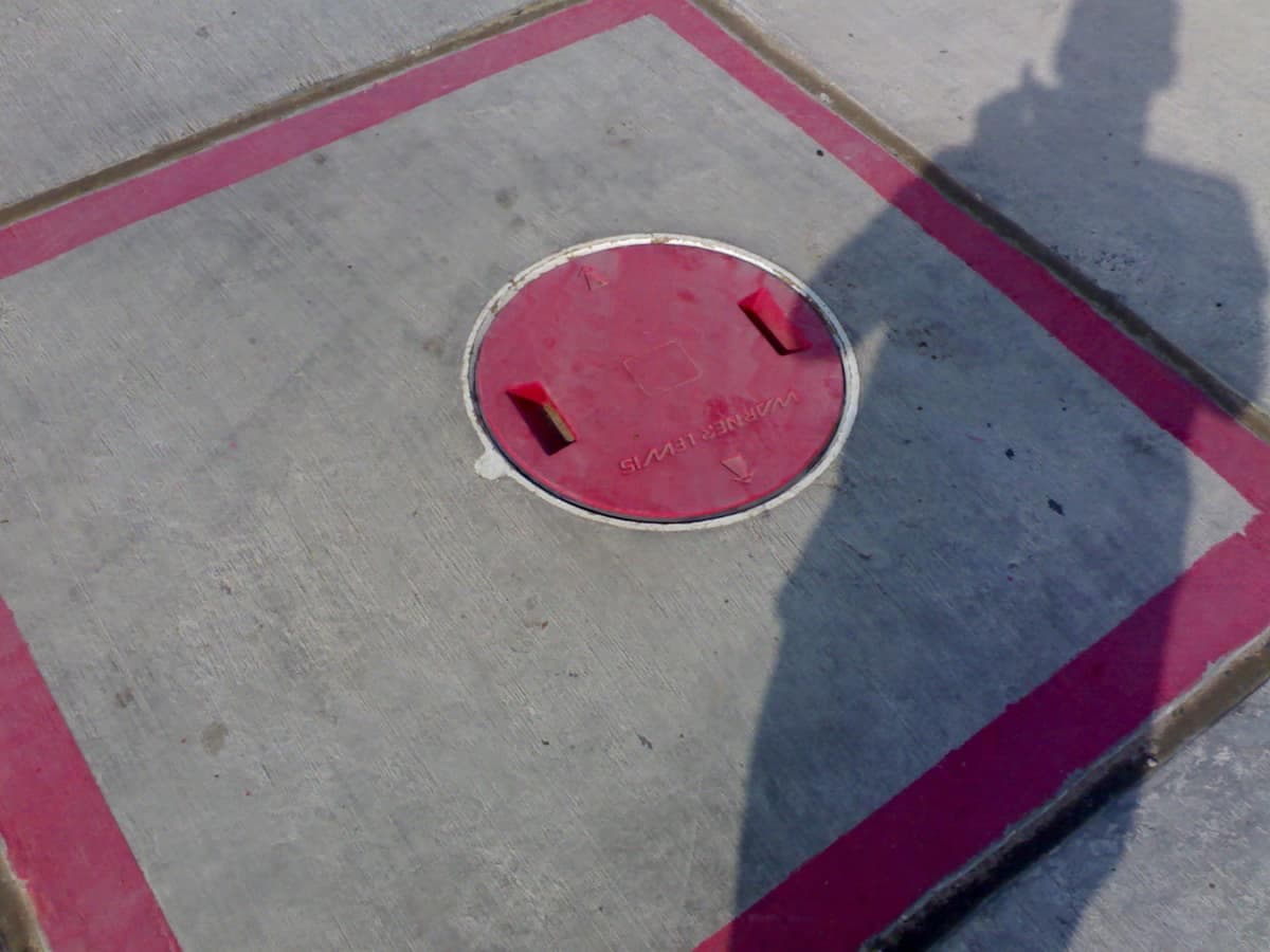 A hydrant pit box set into the concrete apron at Hurghada Airport