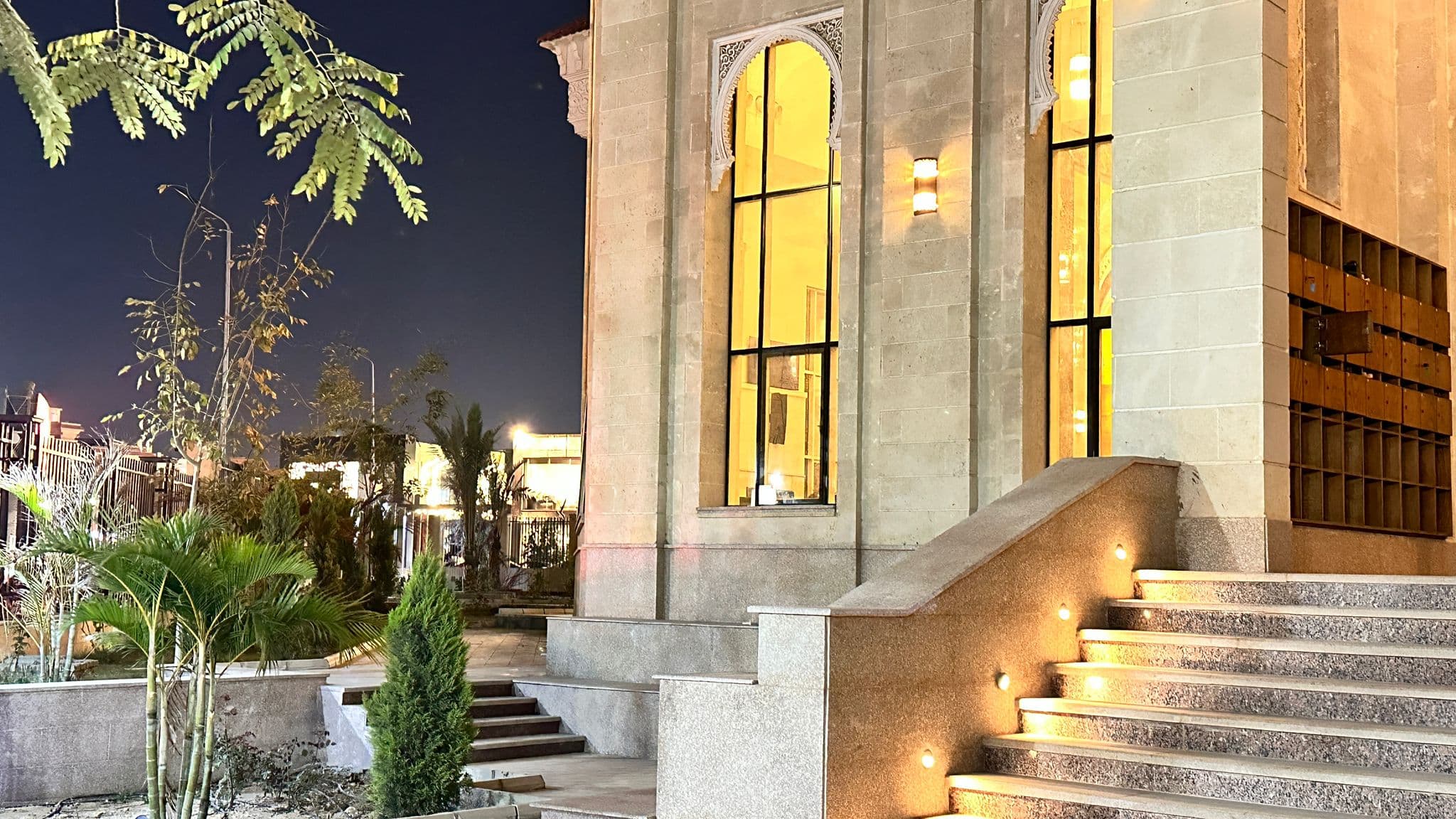 Lit granite steps and stone facade at the side entrance
