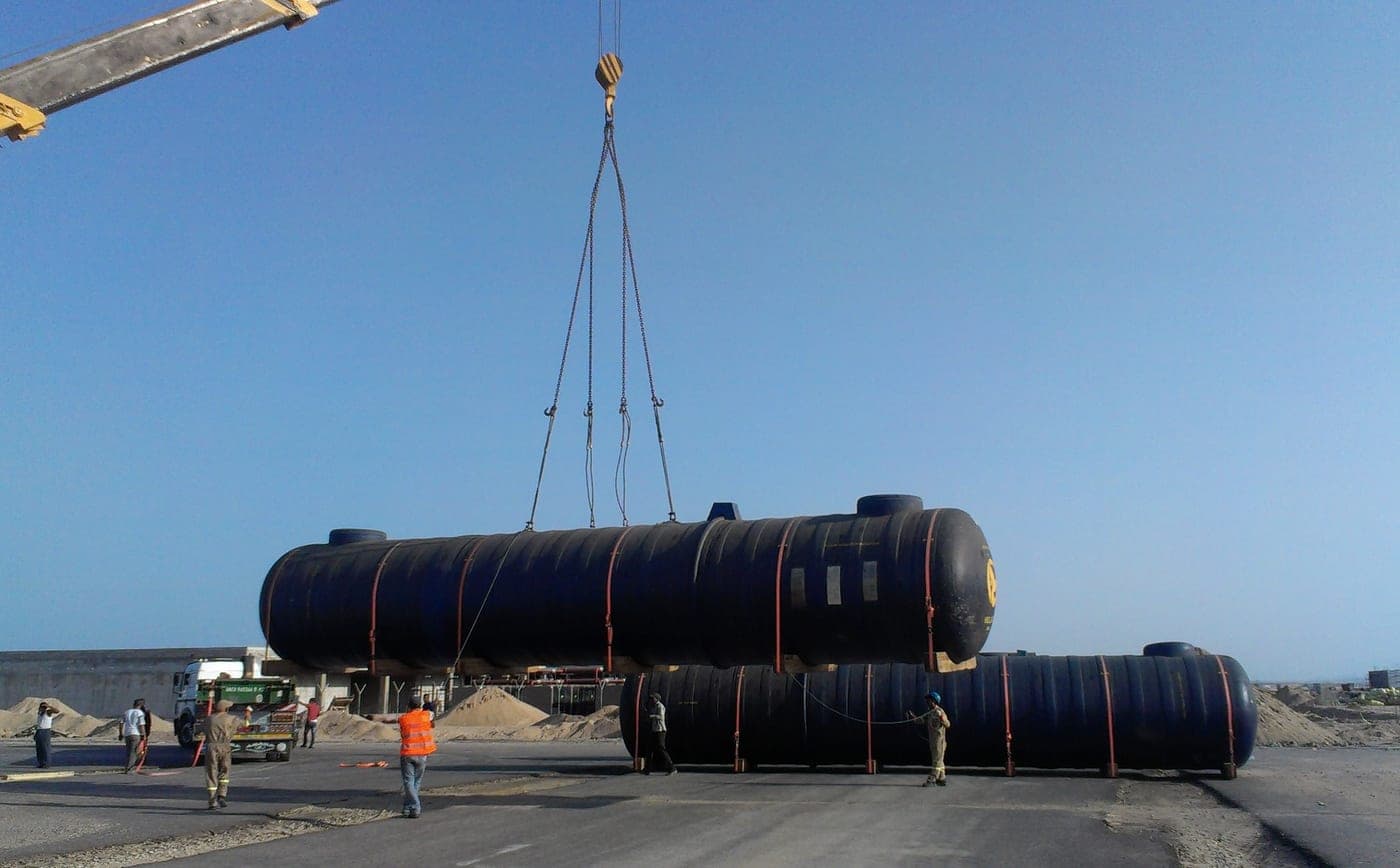 A crane lifting a fuel storage tank into place at the Hurghada Airport depot