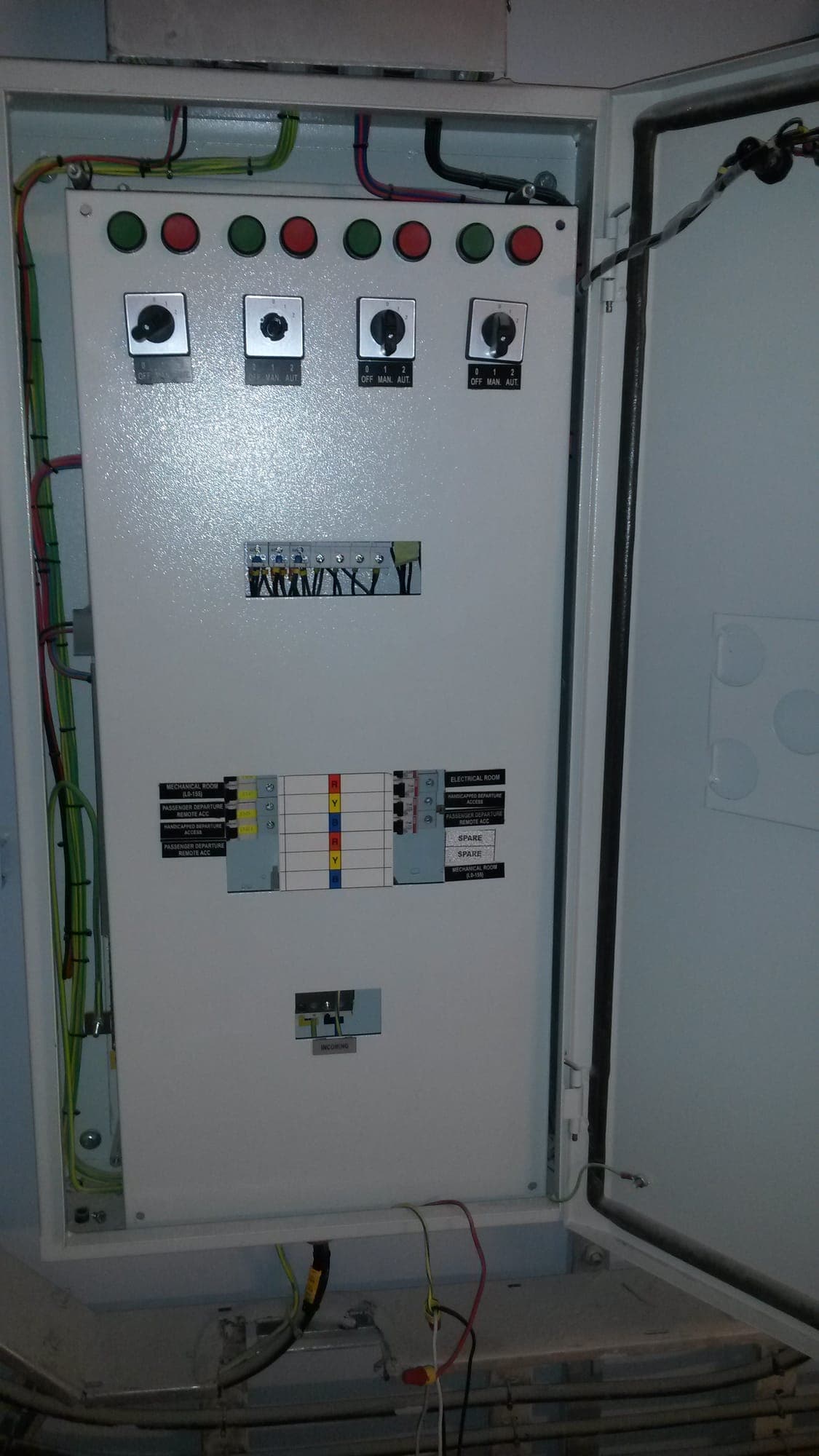 The electrical control panel of a fuel-oil system, its cabinet door open to show indicator lamps, selector switches and labelled circuit breakers