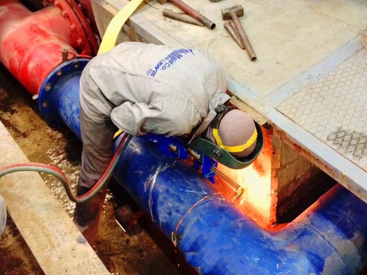 An Al Majd · Warner Lewis technician cutting into valve pipework during maintenance at the Cairo Terminal 2 pump station
