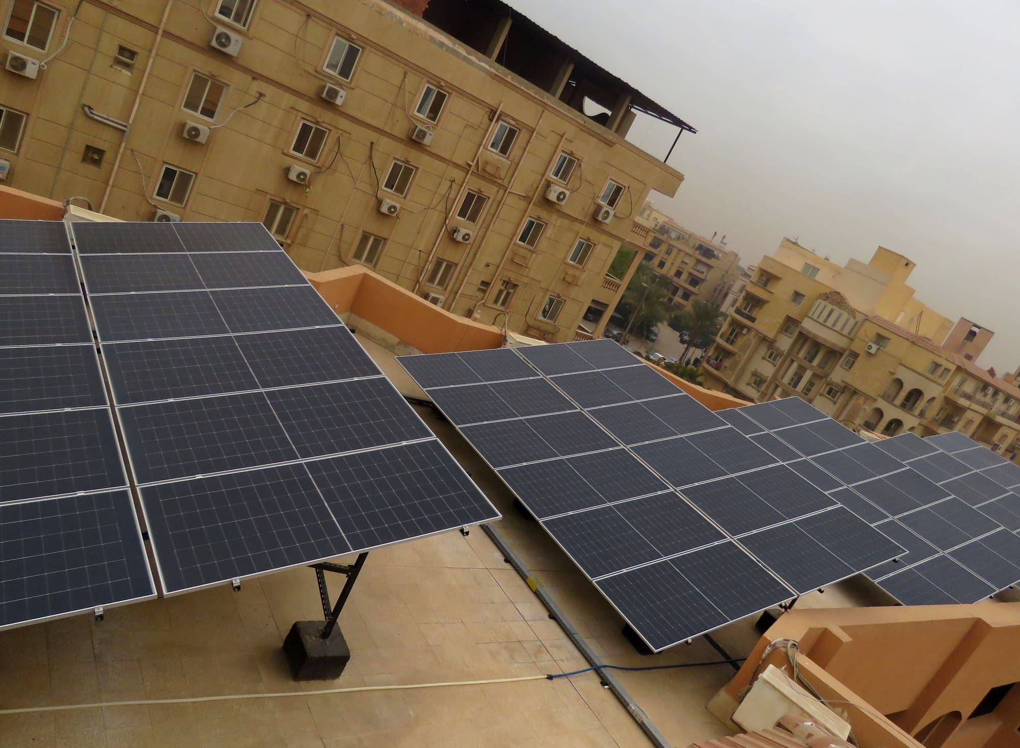 Rooftop solar array installed by Al Majd · Warner Lewis above the New Cairo skyline